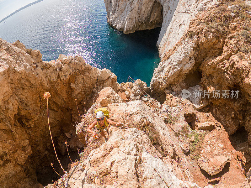 费拉塔岛(Via Ferrata)上的攀登者，年轻的妇女们在攀登海面上的岩石